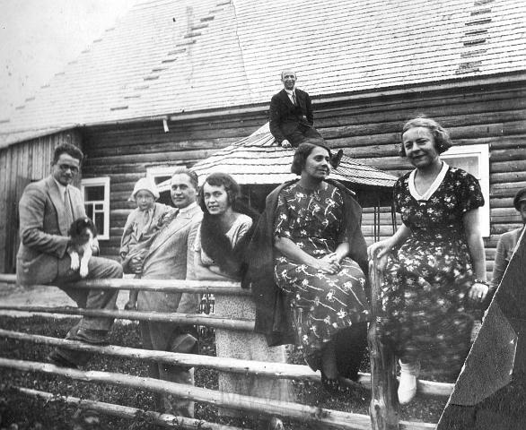 KKE 2472.jpg - Przy domu mieszkalnym nadleśniczego Nadleśnictwa Miory. Na płocie siedzą od prawej: p. Maria Rodziewicz, Maria Zapaśnik. Stoi Teresa Aleksandrowicz, Paweł Aleksandrowicz z córką Mirosławą na ręku. Na dachu altanki p. Henryk Jacewicz – sekretarz w Nadleśnictwie.